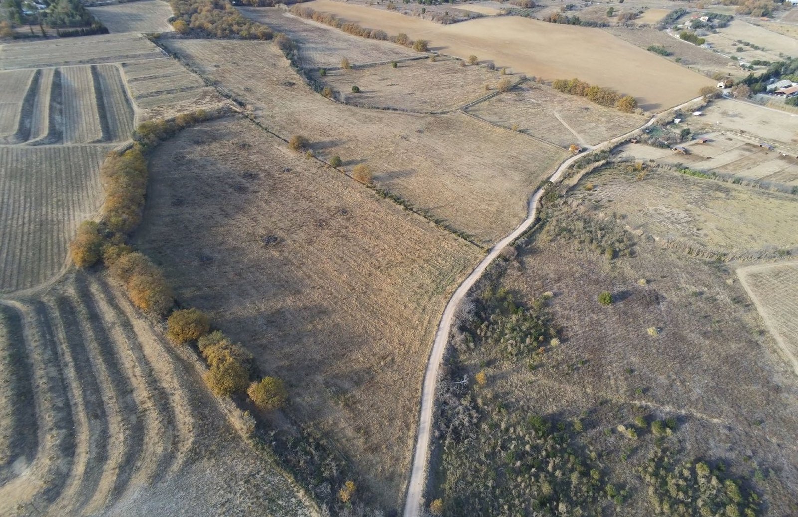Vue aérienne par drone de parcelles agricoles et d’un chemin, avant le projet