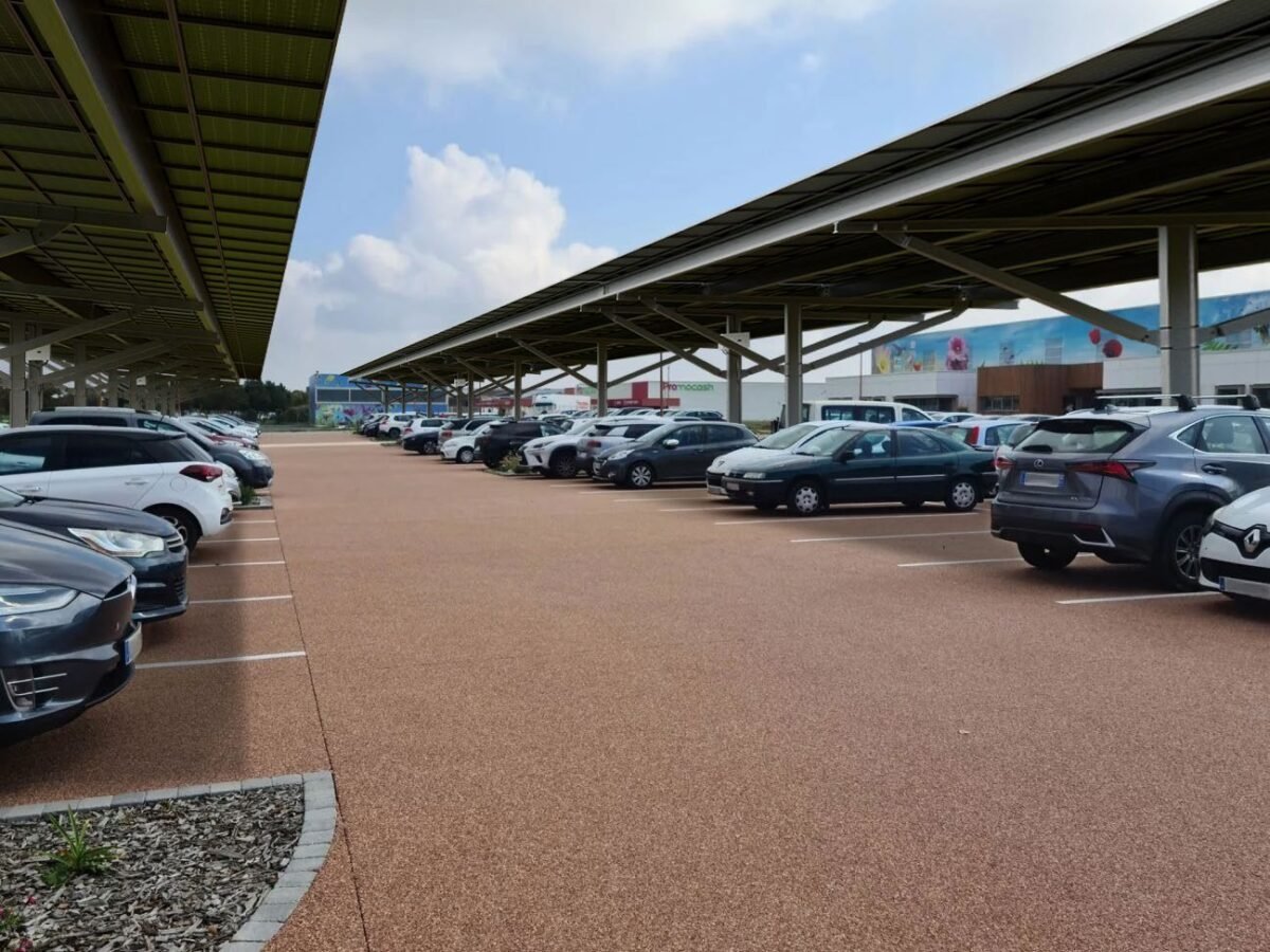 Photomontage d’ombrières photovoltaïques en double rangée sur un parking commercial