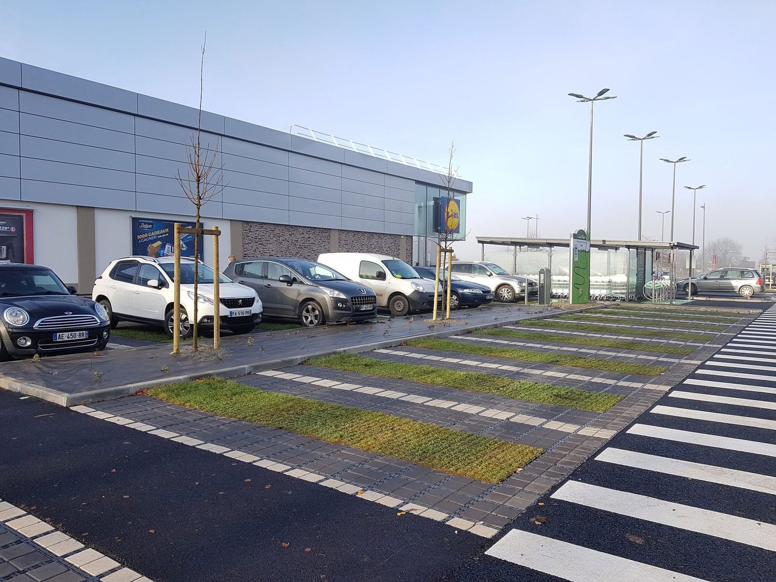 Parking d’un commerce avec places végétalisées, avant le projet