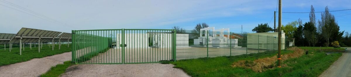 Photomontage du portail, de la clôture et des conteneurs de stockage d’une centrale photovoltaïque en bord de voie